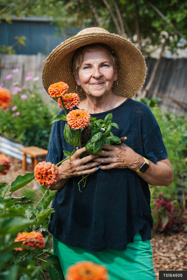 Portrait of woman with dahlia flowers in garden