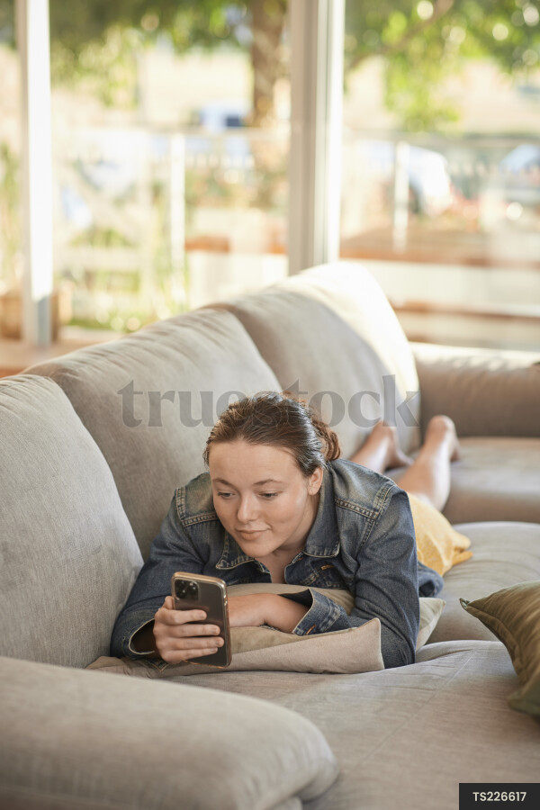 Girl lying on couch with phone