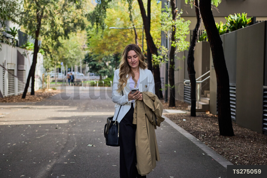 Woman looking at cell phone while walking