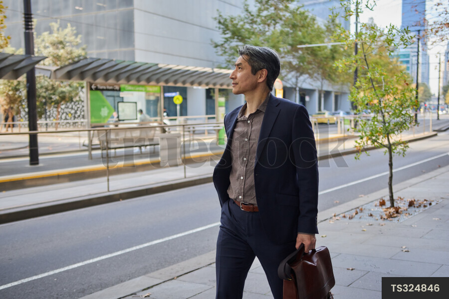 Man carrying bag and walking in city