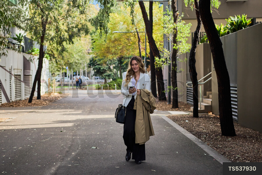Woman walking while looking at cell phone