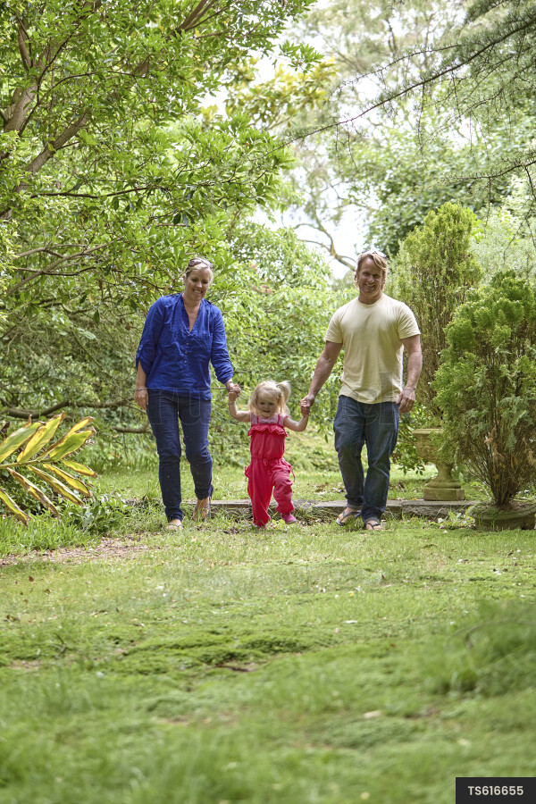 Girl walking with her parents in garden