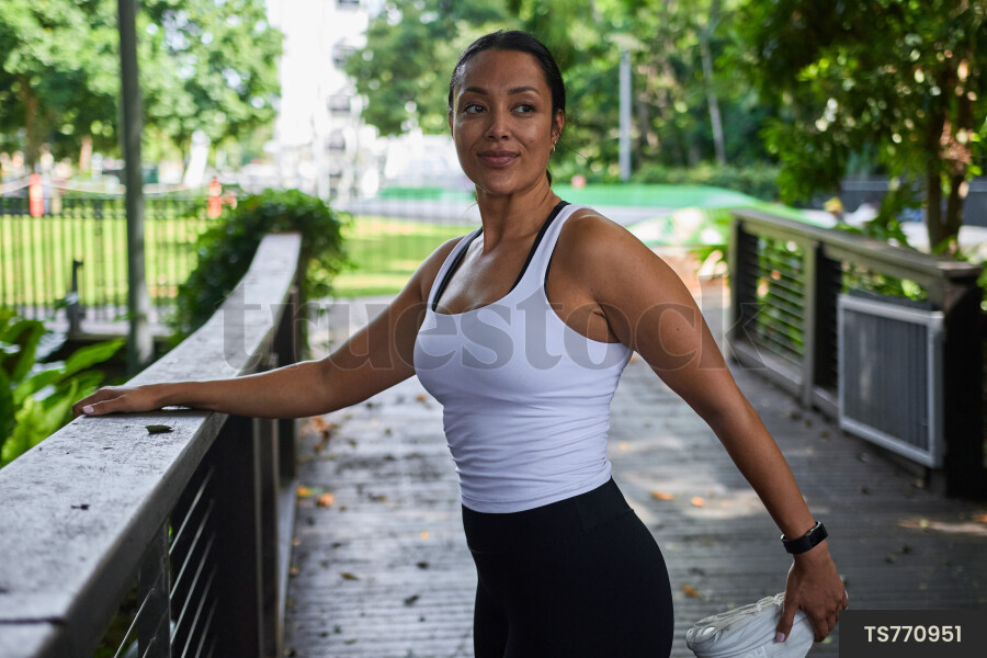 Ethnically ambiguous female stretching at South Bank